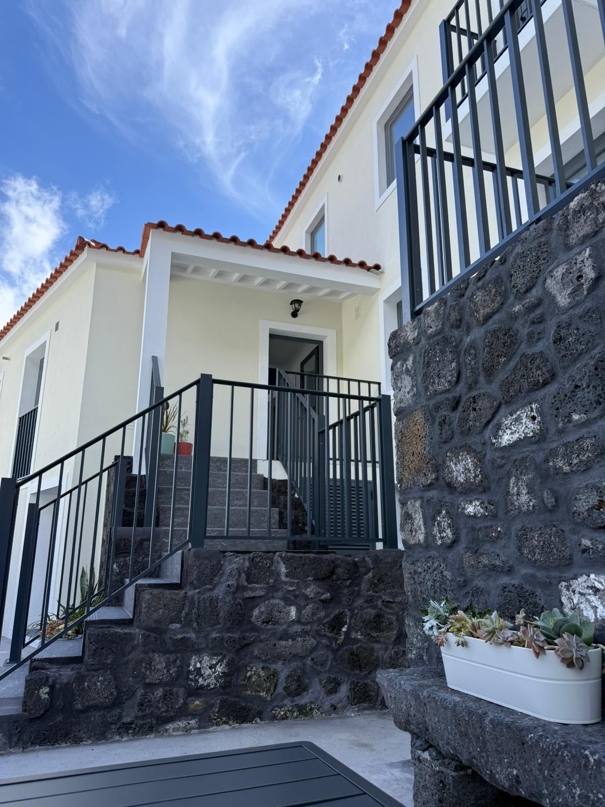 Fachada da Casa do Porto · escadaria de pedra basáltica e céu do Pico