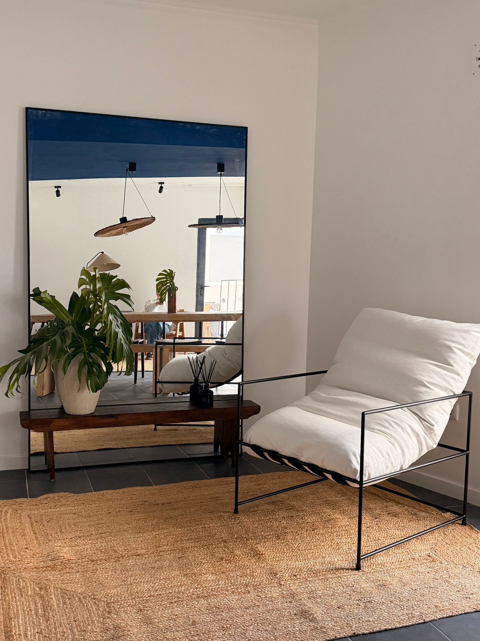 Sala comum da Casa do Porto · espelho, monstera e cadeira de leitura