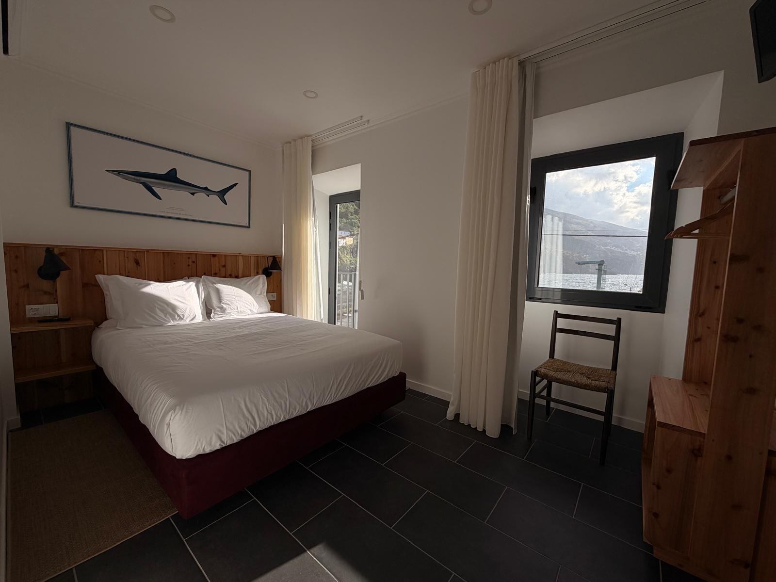 Quarto Q1 Duplo Superior com cama king e varanda sobre o porto